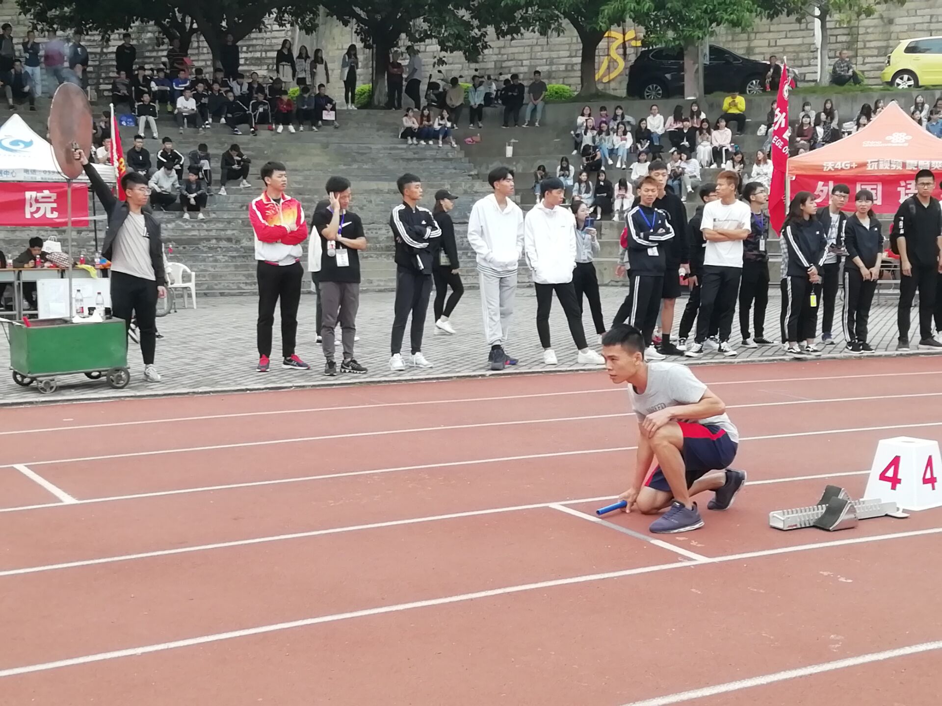 4×400米接力赛在红棕的操场上充满了呐喊与加油,选手间的交棒是信任
