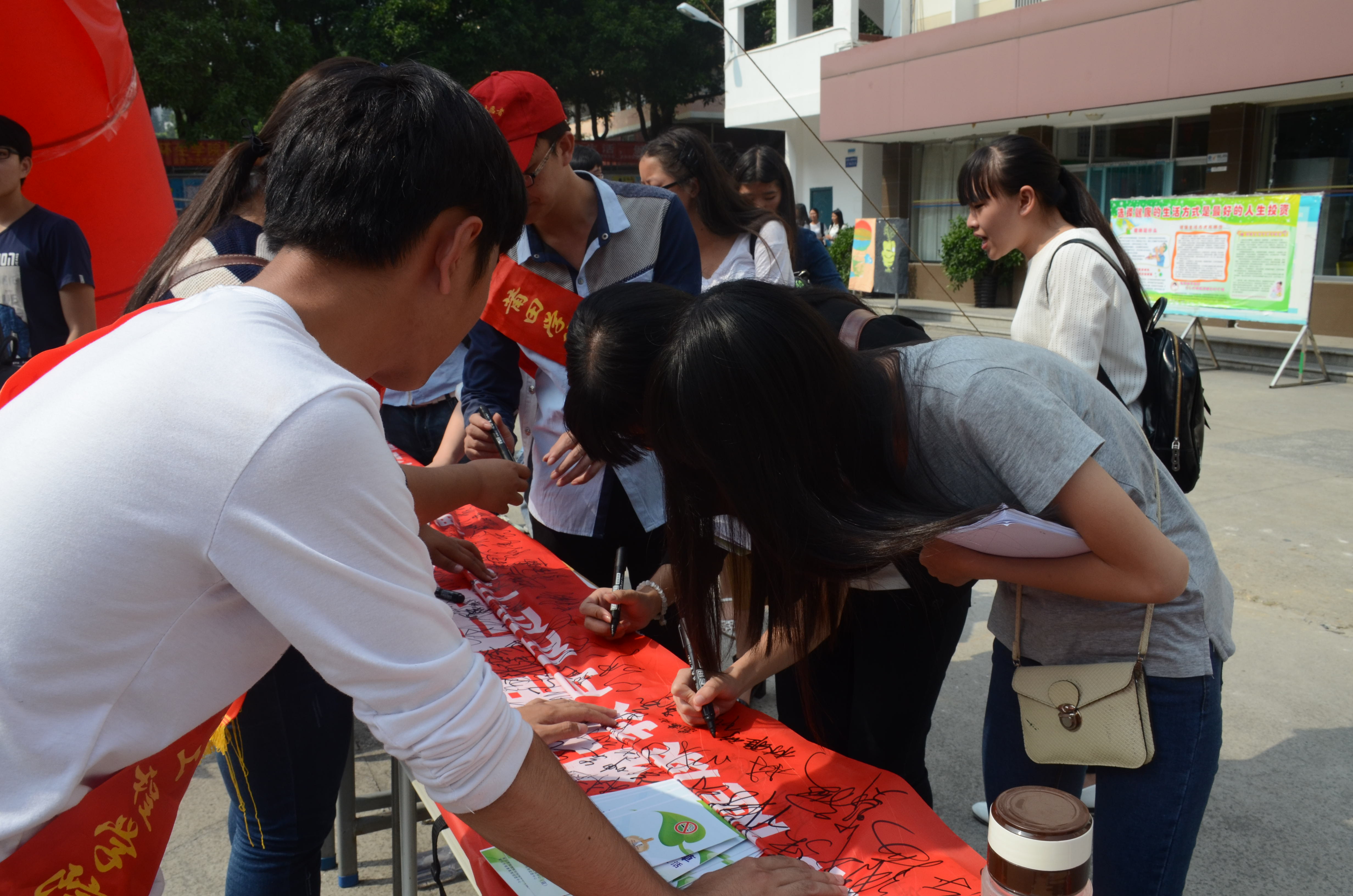 图为同学们为横幅签字